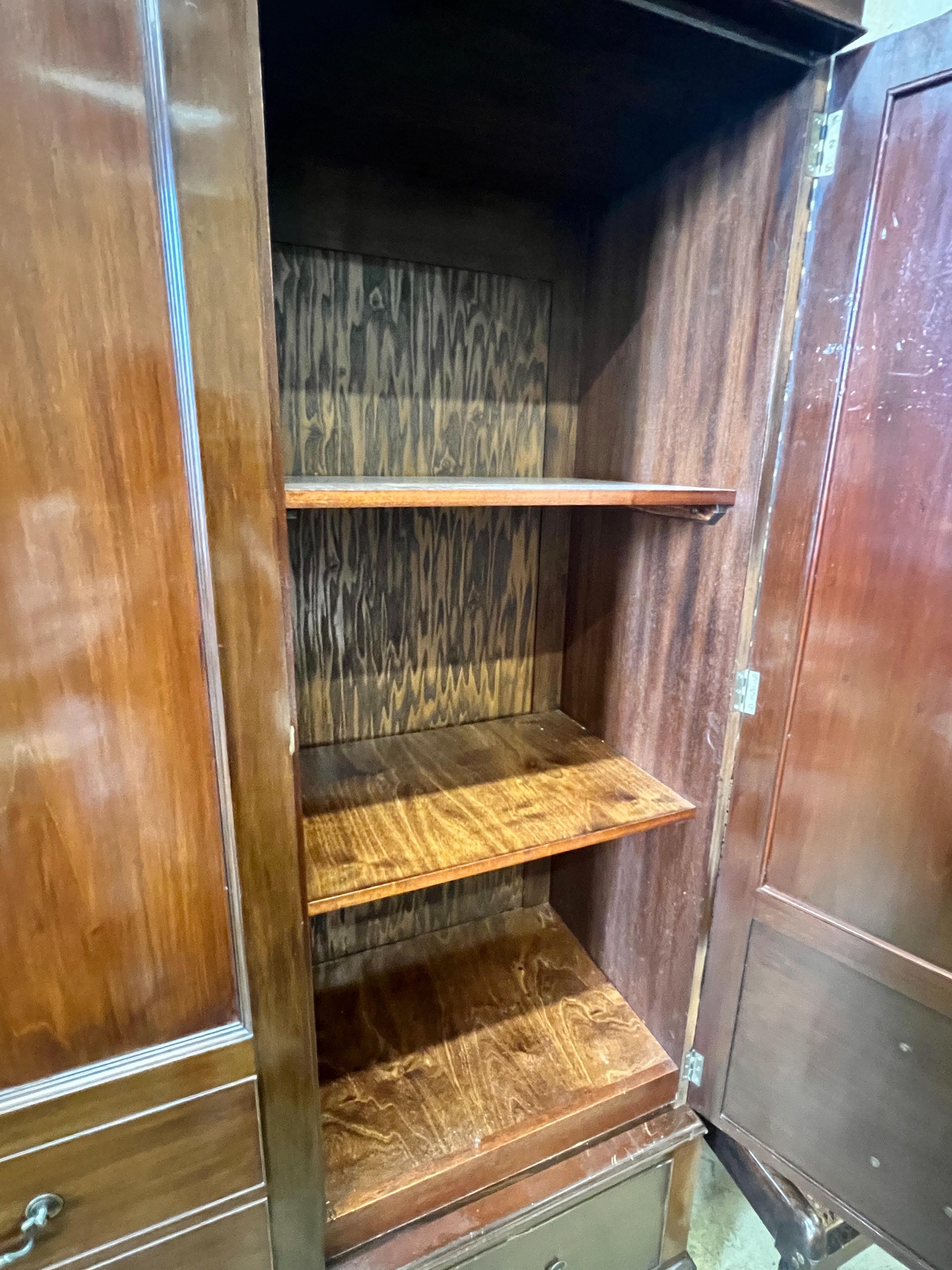 A 1920's mahogany press cupboard with part dummy drawer front over a single drawer, width 120cm, depth 50cm, height 196cm